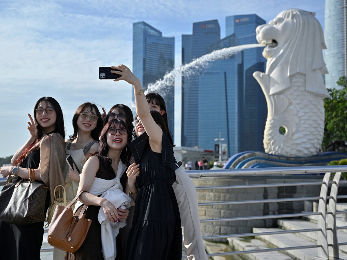 Tourists Posing For Photos In Front Of The Merlion Statue and Singapore  Skyline, Singapore, Stock Photo, Picture And Rights Managed Image. Pic.  YB3-3318696 | agefotostock