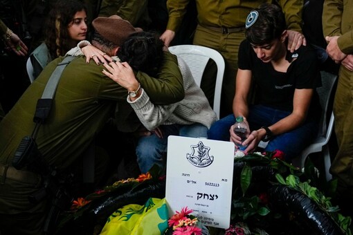 An Israeli soldier consoles Adar Ben Basat, during the funeral of her husband Col. Itzhak Ben Basat, in Kfar Tavor, Israel. He is the senior most Israeli soldier to have been killed during the ground offensive against Hamas in the Gaza Strip. (Image: AP Photo)