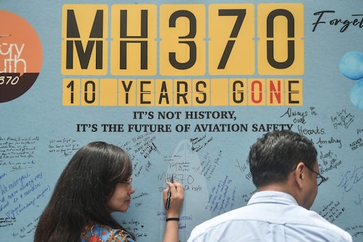 A woman writes a message during a March 3 event held by relatives of the passengers and supporters to mark the 10th year since the Malaysia Airlines flight MH370 carrying 239 people disappeared. (AFP)