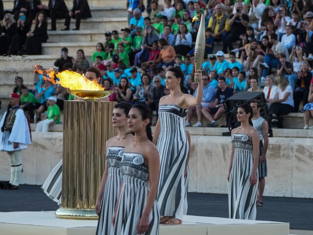 Actress Mary Mina, playing an ancient Greek high priestess, holds a torch with the Olympic flame during the flame handover ceremony. (AP Photo)