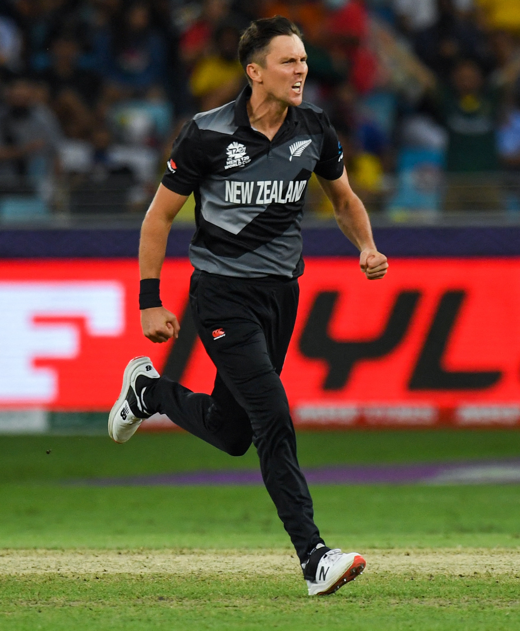 New Zealand's Trent Boult celebrates after bowling out Australia's David Warner (not pictured) during the ICC mens Twenty20 World Cup final match between Australia and New Zealand at the Dubai International Cricket Stadium in Dubai on November 14, 2021. (Photo by INDRANIL MUKHERJEE / AFP)