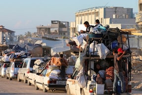 Displaced Palestinians, who fled Rafah after the Israeli military began evacuating civilians from the eastern parts of the southern Gazan city, ahead of a threatened assault, amid the ongoing conflict between Israel and Hamas, travel on a vehicle, in Khan Younis in the southern Gaza Strip. (Image: Reuters)