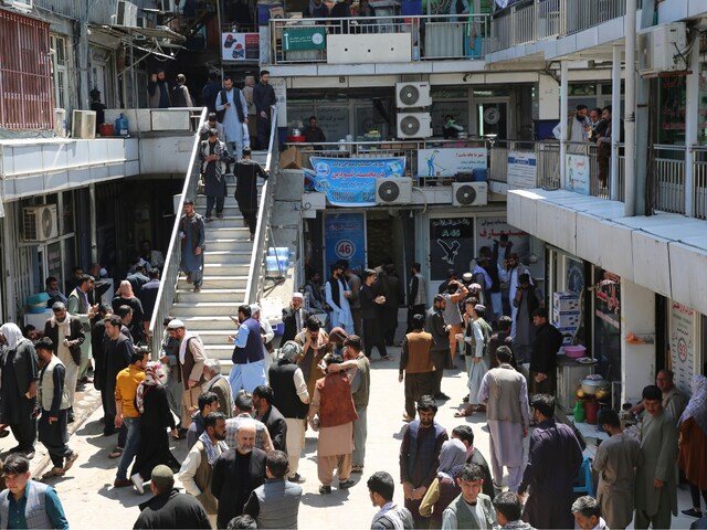 Afghans walk around a downtown currency exchange market in Kabul, Afghanistan, Monday, April 22, 2024. (AP Photo)
