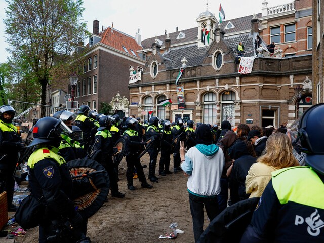 Police officers stand next to pro-Palestinian protesters outside the University of Amsterdam during a protest against the ongoing conflict between Israel and Hamas in Gaza, in Amsterdam, May 8. (Reuters)