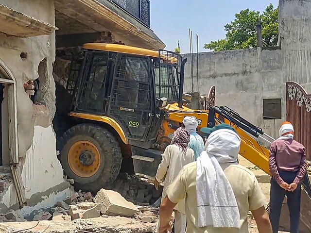 A bulldozer demolishes a house of Zainab Fatima, wife of slain gangster Atiq's brother Ashraf, built on Waqf Board's land, in Prayagraj on June 20. (Image: PTI) (PTI06_20_2024_000259B) 