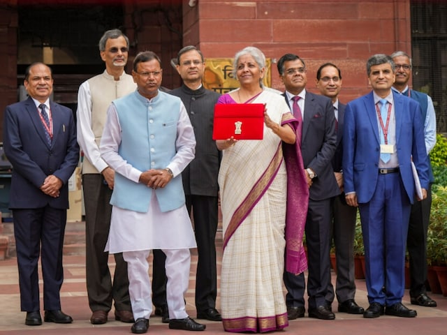 Union Finance Minister Nirmala Sitharaman showcases a red pouch carrying the Budget documents, outside the Finance Ministry in North Block before leaving for the Parliament where she will table the Union Budget 2024-25. (Photo: PTI)