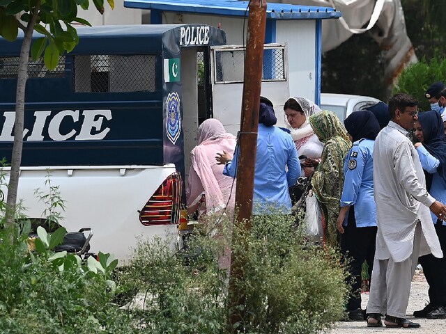 Women police officers taking the arrested female workers of the Pakistan Tehreek-e-Insaf (PTI) from the party's headquarters into police van after a security raid in Islamabad. (Image: AFP)