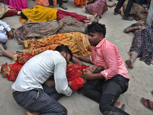 People mourn next to the bodies of their relatives outside a hospital in Hathras. (AP)