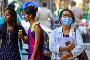 Students sitting in an examination hall, focused on taking a medical entrance exam, with the NEET PG logo in the corner