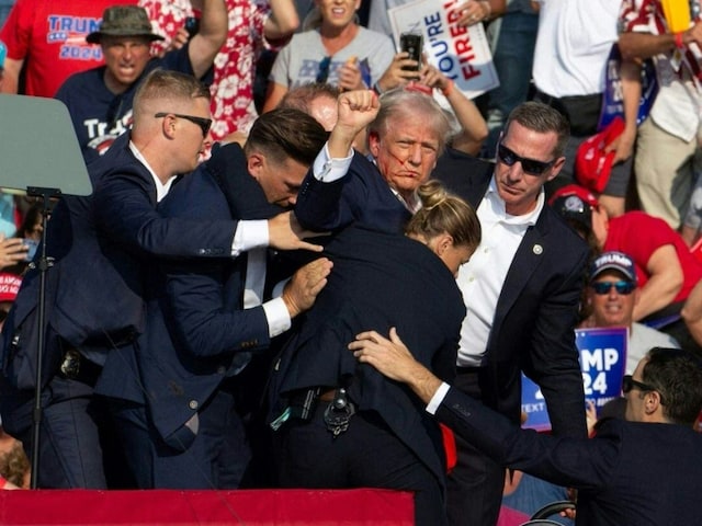 Secret Service agents shield Donald Trump during an assassination bid on the former President. (AFP)