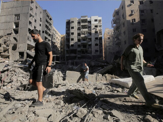 People walk on the rubble at the site of the Israeli airstrike that killed Lebanon's Hezbollah leader Sayyed Hassan Nasrallah on Friday, in Beirut's southern suburbs, Lebanon, September 29, 2024.  (Reuters)