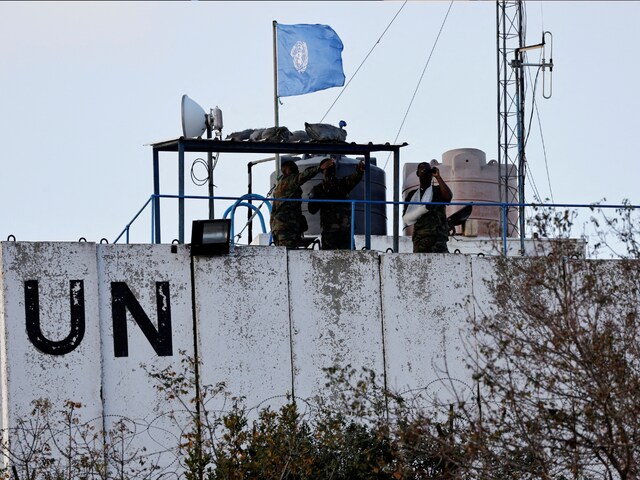 Members of the United Nations peacekeepers (UNIFIL) look at the Lebanese-Israeli border, as they stand on the roof of a watch tower ‏in the town of Marwahin, in southern Lebanon, October 12, 2023. (Reuters)