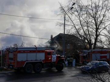 Rescuers stand next to a damaged house following a drone attack in the village of Stanovoye, Moscow region, on Sunday (AFP)