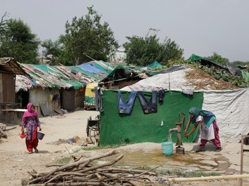 A Rohingya refugee woman draws water from a hand pump at a temporary shelter in New Delhi. (AP file photo)
