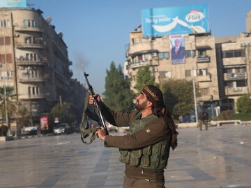 A Syrian opposition fighter shoots in the air in downtown Aleppo, Syria, on November 30. (AP Photo)