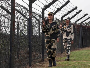 BSF personnel patrol past a fence on the India-Bangladesh border at Thakuranbari village, in the northeastern Indian state of Assam. (AP File)