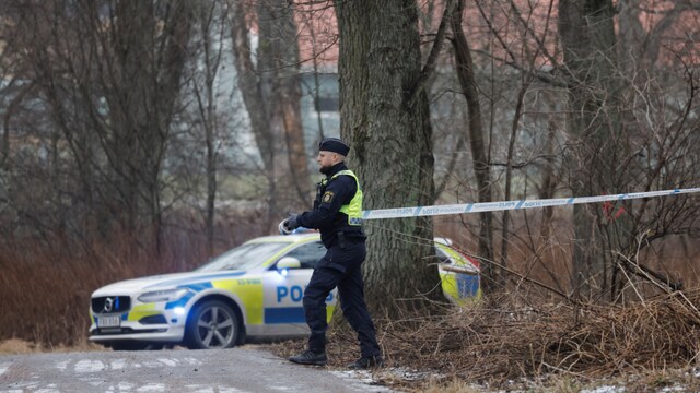 An officer unrolls police tape as a major police operation is underway at Risbergska School, following reports of a serious violent crime, in Orebro, Sweden (Reuters)