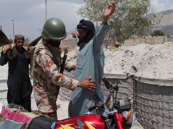 A paramilitary soldier frisks motorbike riders, a day after separatist Baloch militants conducted deadly attacks, on the outskirts of Quetta, Pakistan. (IMAGE: REUTERS) A paramilitary soldier frisks motorbike riders, a day after separatist Baloch militants conducted deadly attacks, on the outskirts of Quetta, Pakistan. (IMAGE: REUTERS)