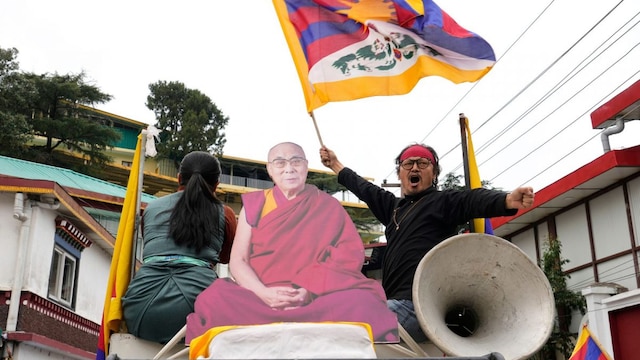 An exiled Tibetan waves the national flag as Tibetans mark the 66th anniversary of an uprising in Tibet's capital Lhasa, by participating in a march in Dharamshala. (PTI)