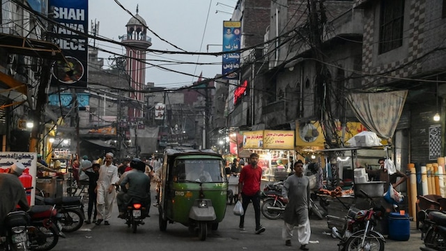 This photograph taken on May 16, 2024 shows commuters moving along a street at the royal neighbourhood of Heera Mandi, a red-light zone, in Lahore. (Photo by AFP)