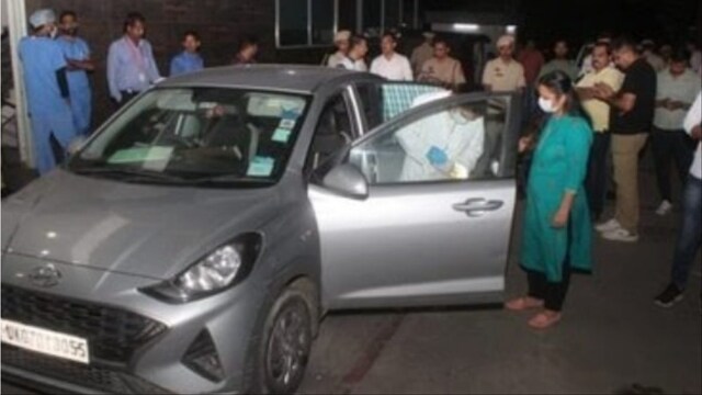 Officials inspecting the car in which the family was found dead (Social Media)