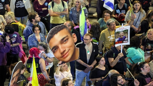 A demonstrator holds a sign showing the face of US-Israeli hostage Edan Alexander. (AFP)