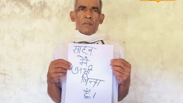 The couple approached government offices carrying a placard that read, "Saheb, main abhi zinda hoon (Sir, I'm still alive)."