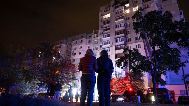 People look at an apartment building that was damaged in a Russian drone attack (Reuters image)