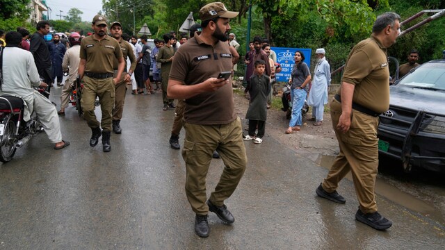 Police officers arrive to control crowd gathered at an entry point to a garrison area, in Lahore on May 8, 2025. (AP)