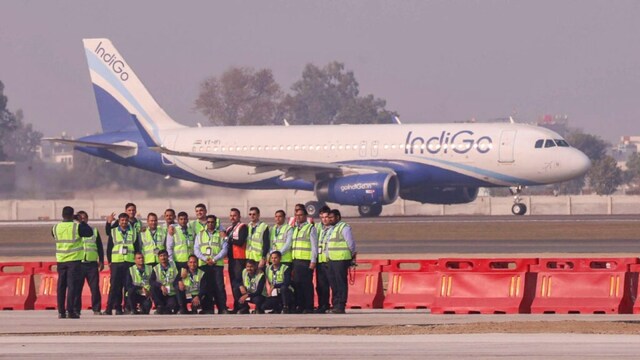 Airport officials pose for a photograph after the successful landing of the first test flight at Noida International Airport, at Jewar in Gautam Buddha Nagar district, Uttar Pradesh in December 2024. (PTI Photo)