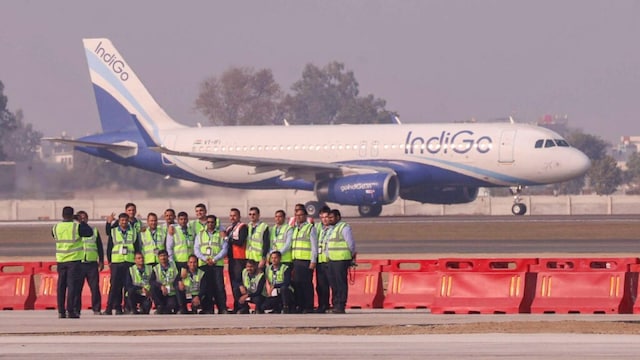 Airport officials pose for a photograph after the successful landing of the first test flight at Noida International Airport, at Jewar in Gautam Buddha Nagar district, Uttar Pradesh in December 2024. (PTI Photo)