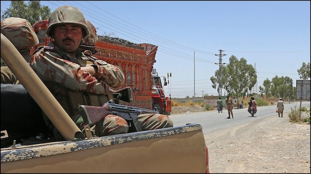 Security personnel guard along a street near the site of a school bus bombing in Balochistan's Khuzdar. (AFP)
