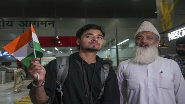 An Indian student returning from Iran stands with a relative while exiting from the Indira Gandhi International Airport, in New Delhi. (PTI)