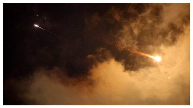 Rocket trails are seen in the sky above the Israeli coastal city of Netanya amid a fresh barrage of Iranian missile attacks on June 21. (AFP)