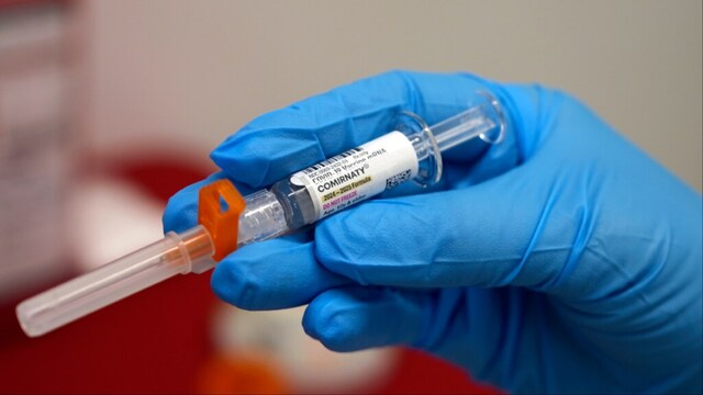A pharmacist holds a COVID-19 vaccine at a pharmacy (File photo/PTI)