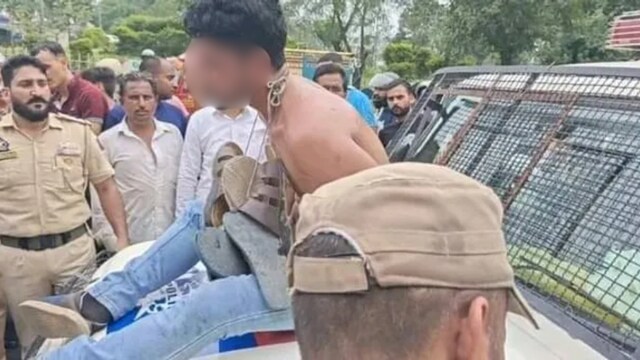 The video showed the man - stripped to the waist - on the bonnet of a police jeep. (X)
