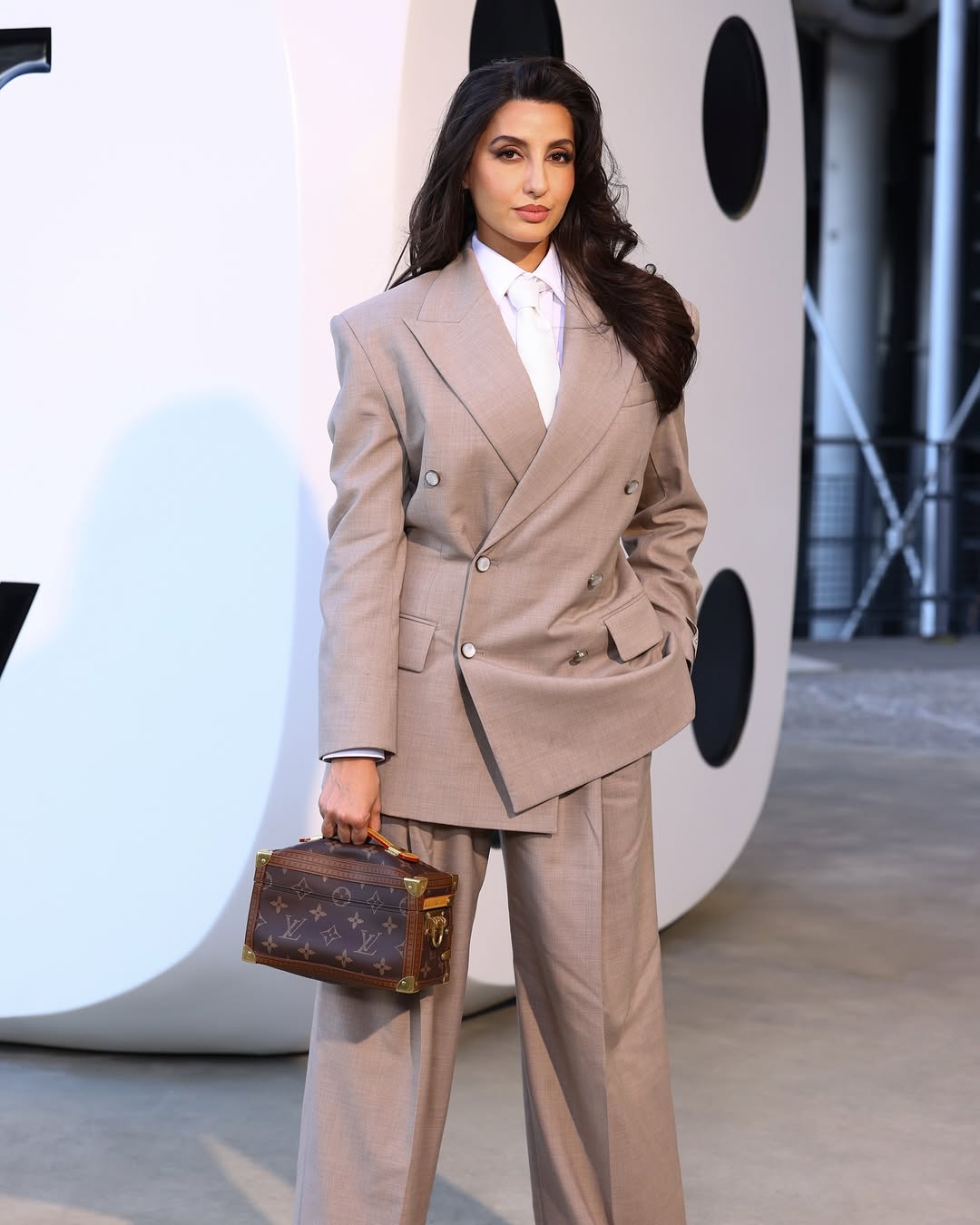 Nora Fatehi stunned in a beige pantsuit which she paired with a crisp white shirt and a tie. (Image: Instagram) Nora Fatehi stunned in a beige pantsuit which she paired with a crisp white shirt and a tie. (Image: Instagram)