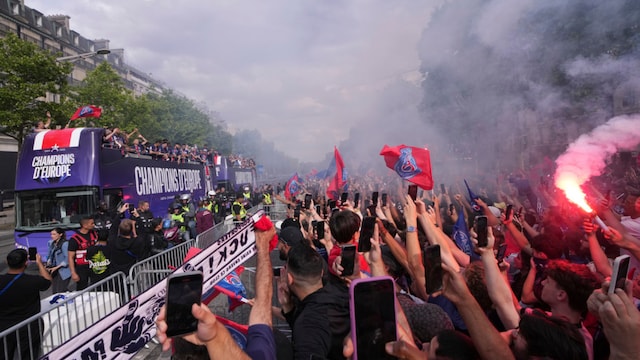 Fans cheer during a parade on the Champs-Elysee avenue after PSG  won the UEFA Champions League (AP)