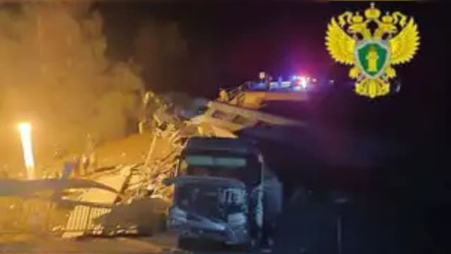 A view shows a damaged bus and a train carriage at the scene, after a road bridge collapsed onto railway tracks in the Bryansk region, Russia, in this image released June 1, 2025.