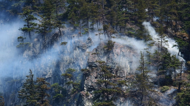 This photograph shows wildfires burning in the hills north of Tantalus Road, in Squamish, British Columbia on June 11, 2025. (AFP)