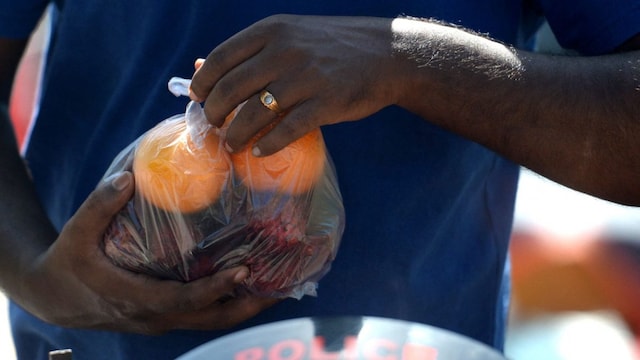 A man carry fruits in single use plastic bags at a local market in Chennai on July 1, 2022. India imposed a ban on many single-use plastics on Friday in a bid to tackle waste choking rivers and poisoning wildlife, but experts say it faces severe headwinds from unprepared manufacturers and consumers unwilling to pay more. (Photo by Arun SANKAR / AFP)