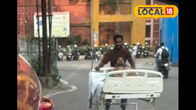 The patient is seen being wheeled from one ward to another under the open sky, without the support of any healthcare worker. (Local18)