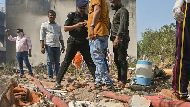Security personnel and volunteers at the site of the Air India plane crash. (PTI)