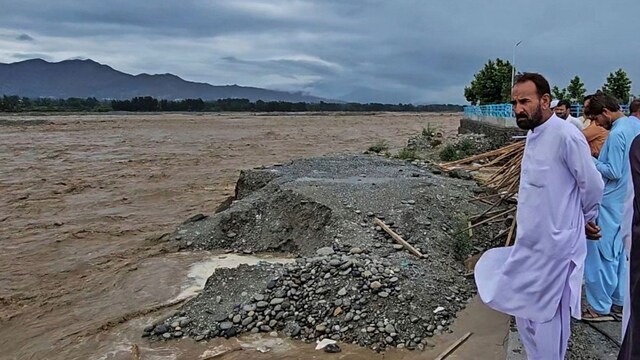 Locals look at the overflowing Swat River  on Friday. (AP)