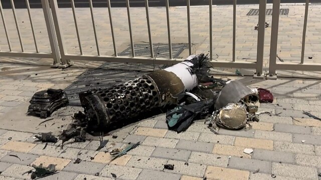 The remnants of an Iranian missile intercepted over Qatar, as it lies on a pavement. (AFP)