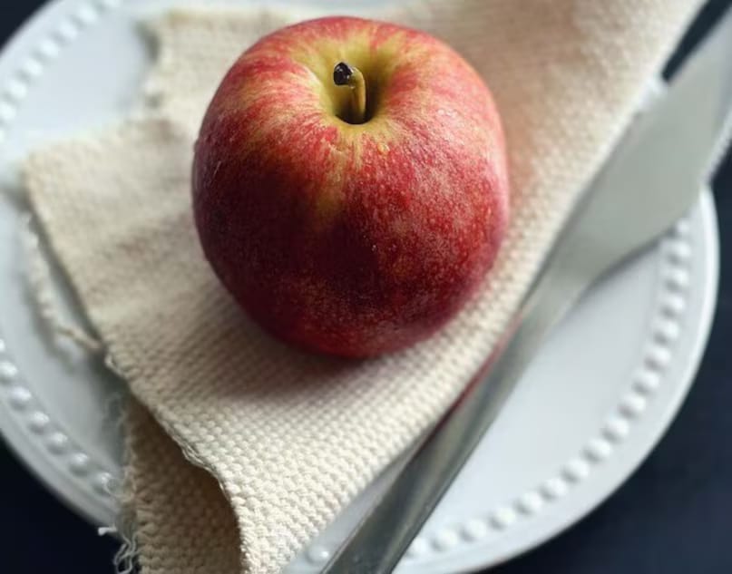 Examine the surface texture or pattern of the apple’s skin. Just like colour, these patterns can help determine the apple variety. Known as textures, they may appear striped, spotted, pinkish, smooth, rough, or uniformly coloured. For instance, if your apple is predominantly red with yellow stripes or spots, it may be a ‘Cameo’ or ‘Jona Gold’. If there’s more yellow than red, it’s likely a ‘Gala’ apple. These natural traits help distinguish real fruits from chemically altered ones. (News18 Hindi) Examine the surface texture or pattern of the apple’s skin. Just like colour, these patterns can help determine the apple variety. Known as textures, they may appear striped, spotted, pinkish, smooth, rough, or uniformly coloured. For instance, if your apple is predominantly red with yellow stripes or spots, it may be a ‘Cameo’ or ‘Jona Gold’. If there’s more yellow than red, it’s likely a ‘Gala’ apple. These natural traits help distinguish real fruits from chemically altered ones. (News18 Hindi)