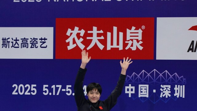 Yu Zidi celebrates on the podium of the 2025 National Swimming Championships in Shenzhen (China). (AP)