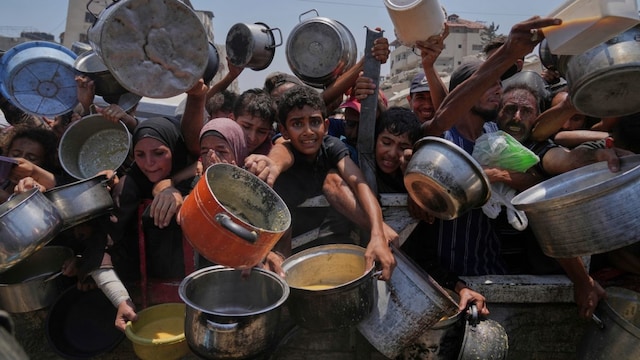 Palestinians struggle to get donated food at a community kitchen, in Gaza City, northern Gaza Strip, Saturday. (AP photo)

