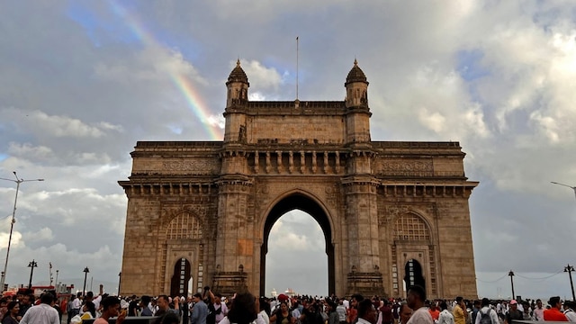 Tourists are seen at the promenade of the iconic Gateway of India as a rainbow is formed on the horizon in Mumbai. (AFP file photo)