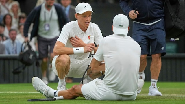 Jannik Sinner (left) checks on Grigor Dimitrov after he went down with an injury. (AP Photo)